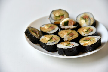 Rice rolls with salmon and cheese on a white plate. Japanese sushi.