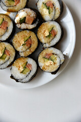Rice rolls with salmon and cheese on a white plate. Japanese sushi.