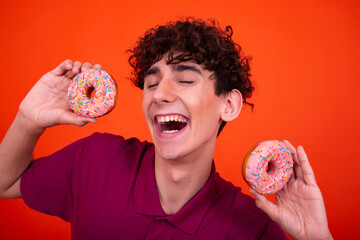 Funny guy eats pink donuts.