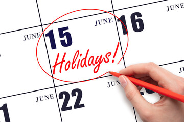 Hand drawing a red circle and writing the text Holidays on the calendar date 15 June. Important...