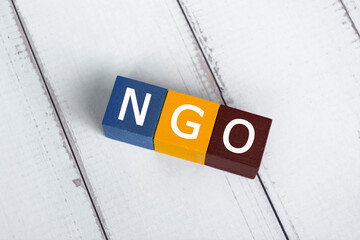 NGO acronym for Non-Governmental Organization on colorful wooden cube.