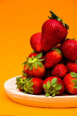 Fresh strawberries on orange background