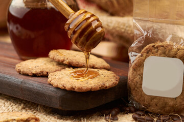 Homemade cookies made in an artisanal way, using a wooden server, honey is placed on a cutting...