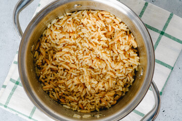 Pot of rice pilaf close up on kitchen table directly from above