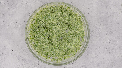 Mascarpone and spinach mix close up in a glass bowl on light grey background. Spinach lasagna recipe