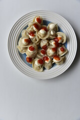 Cooked dumplings on a plate with ketchup and mayonnaise