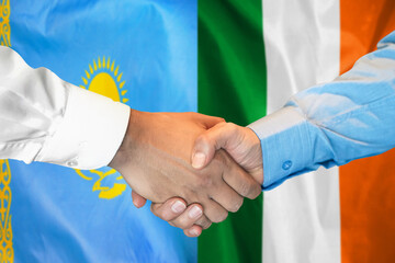 Handshake on Kazakhstan and Ireland flag background. Support concept