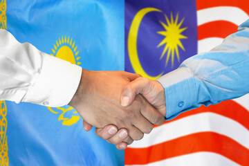 Handshake on Kazakhstan and Malaysia flag background. Support concept