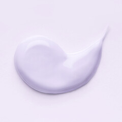 Lilac smear of cosmetic clay or cream on a pastel background.