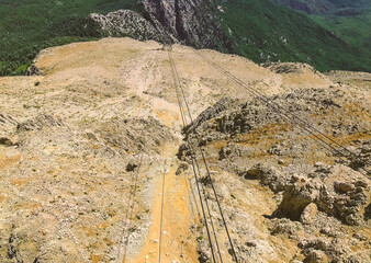 cable car on a mountain in a hot country. lifting to a hill with the help of reliable and strong ropes. carriage with passengers travels through the air