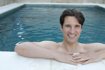 Handsome man smiling in a swimming pool