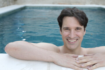 Handsome man smiling in a swimming pool