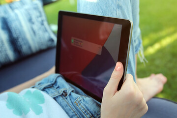 Teen girl  is checking social media holding smartphone outside.