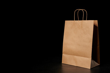 A brown paper bag on a black background. - Powered by Adobe