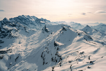 Fototapeta na wymiar Snow-covered mountains in a soft light, view from Schilthorn in Bernese Alps, Switzerland