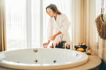 Beautiful woman relaxing at spa.Young lady in bathrobe getting ready for taking the bath. - obrazy, fototapety, plakaty