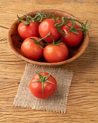 Red tomatoes in a bowl over wooden table