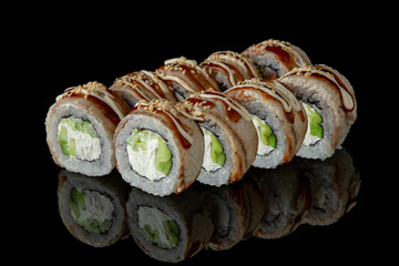 Sushi roll with smoked eel, avocado and cream cheese on black background. Sushi menu. Japanese food.