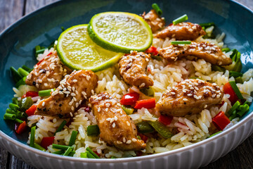 Teriyaki chicken nuggets with rice and vegetables on wooden table
