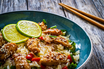 Teriyaki chicken nuggets with rice and vegetables on wooden table
