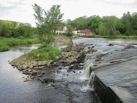 High weir on the river, trees, stones, landscape