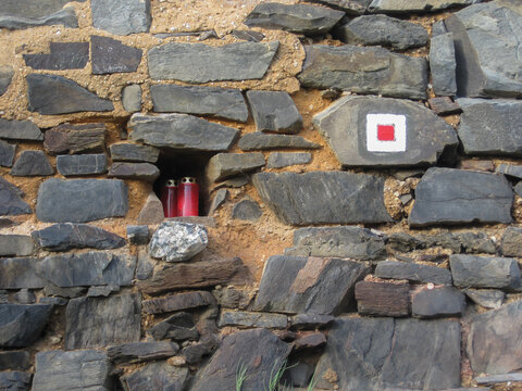 A stone wall and a niche with candles in it
