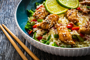 Teriyaki chicken nuggets with rice and vegetables on wooden table
