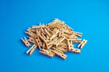 Little wooden clothespins on a blue background.