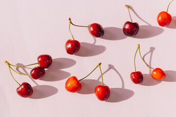 Composition of sweet cherries on a pink background