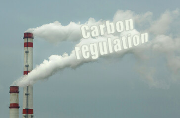 From the pipe of an industrial enterprise comes smoke with the inscription - Carbon regulation, which pollutes the air.