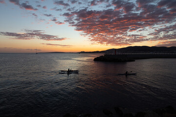 Gente practicando kayak (piragüismo) junto a un puerto de Palma de Mallorca a la puesta de sol....