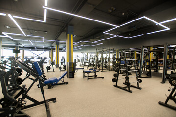 Fototapeta na wymiar Image of beautiful modern gym with different sports equipments and barbells for weight training