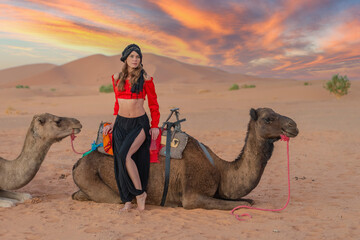 A Lovely Model Rides A Dromedary Camel Through The Saharan Desert On Their Camels In Morocco