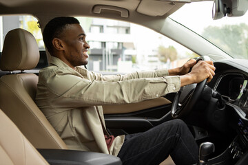 Side portrait of happy african american man driving car