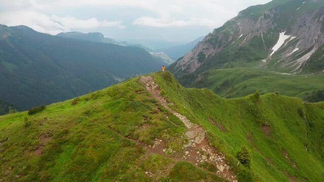 4K drone rotating footage around woman standing on top of mountain in Italian Alps. Travelling, hiking, landscapes concept.
