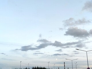 Light blue sky with clouds. Above high lanterns under a light blue sky, rare cumulus clouds of...