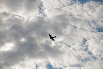 silhouette of a training plane flies in the sky against the sun, 