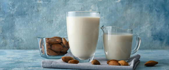 Jug and glass of almond milk on table