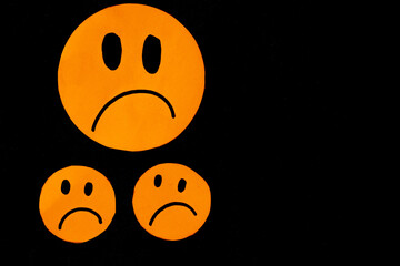 sad orange emoticons on black background concept of dissatisfaction, displeased, uncomfortable,...