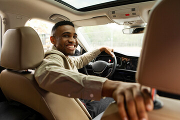 Joyful Afro American Man Smiling Sitting In Automobile Looking Back At Camera