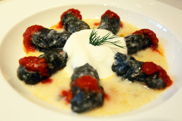 Stuffed chard with tomato sauce and yogurt on the dinner plate.