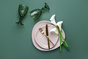 Beautiful table setting with white calla lilies on color background