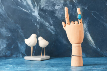 Wooden hand with stylish ring on grunge background