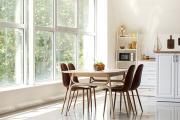 Fruit basket on dining table near big window in kitchen