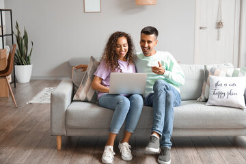 Happy young couple video chatting at home