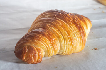 Delicious homemade croissants on a white parchment paper,natural light