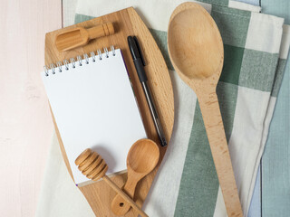 Notepad on cutting board with wooden kitchen utensils on the table, food recipes .copy space