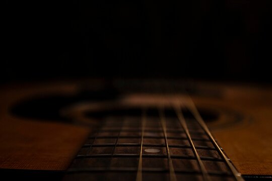 Guitar.Guitar's chords.Acoustic guitar.Music.Music background.Image of an acoustic guitar in the dark.Playing music with some friends in the dark.Classical music.Guitar closeup..