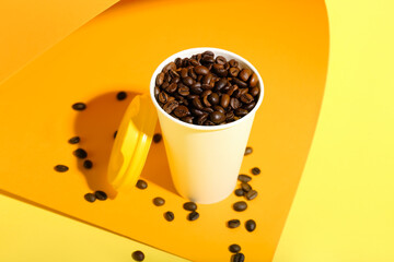 Takeaway paper cup with coffee beans on color background