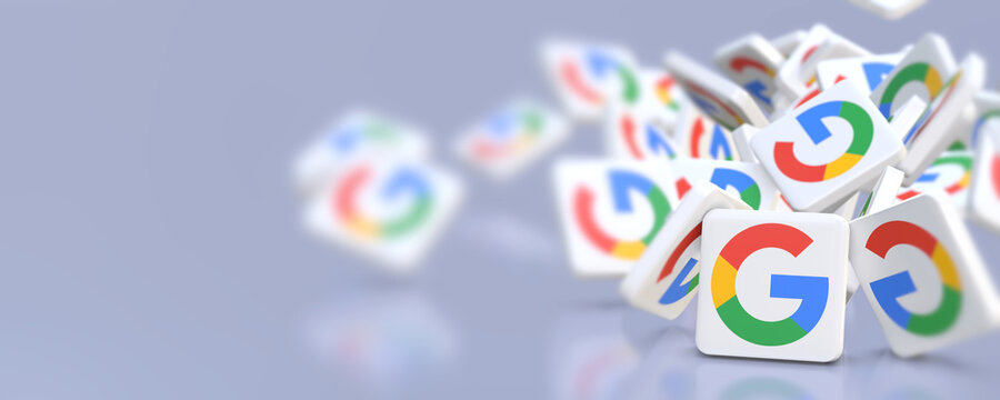 Google company logos fall on a table. Banner format with copy space and selective focus.
